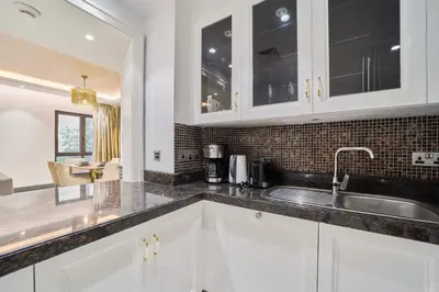 a kitchen with white cabinets and a sink at FAM Living - 2 Bedroom Old Town Dubai Stay in Dubai