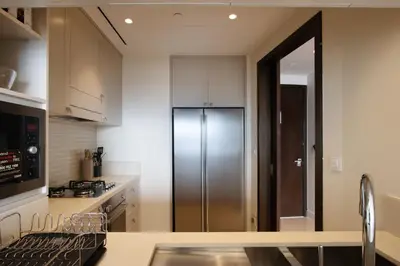 a kitchen with white cabinets and a refrigerator at Unobstructed Burj Fountain View Near Dubai Mall in Dubai