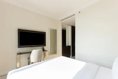 a bedroom with a white bed and a tv at Unobstructed Burj Fountain View Near Dubai Mall in Dubai