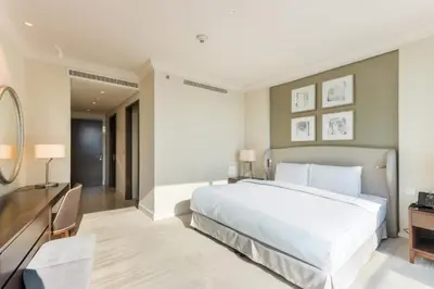 a bedroom with a large white bed and a desk at Unobstructed Burj Fountain View Near Dubai Mall in Dubai