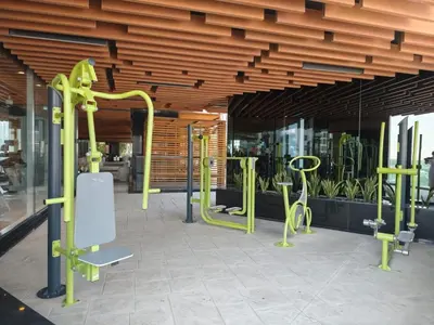 a gym with green equipment in front of a building at Burj View 1BHK near Down Town - Panoramic Balcony View -Pool and Gym in Dubai