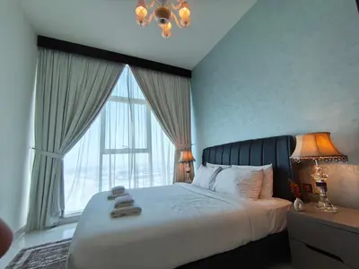 a bedroom with a large bed with a large window at Burj View 1BHK near Down Town - Panoramic Balcony View -Pool and Gym in Dubai