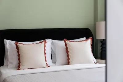 a bed with white pillows and a black headboard at Meydan - Modern Family - 2BR Apartment - Azizi Riviera in Dubai