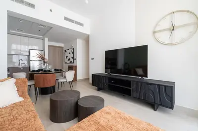 a living room with a large television and a table at Meydan - Modern Family - 2BR Apartment - Azizi Riviera in Dubai