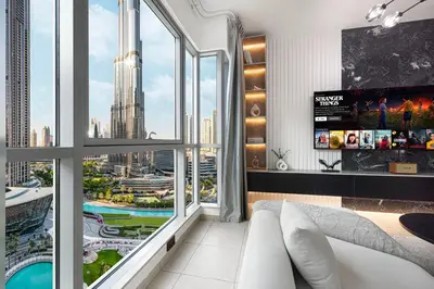 a living room with a large window with a view of a city at Restay Homes at The Residences Tower 1 - Full Burj Views from all apartments in Dubai