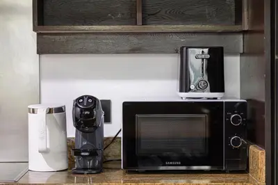 a microwave sitting on top of a counter with a blender at Restay Homes at The Residences Tower 1 - Full Burj Views from all apartments in Dubai