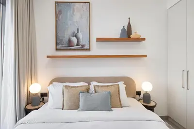 a bedroom with a white bed with two lamps at Upscale 4BR Villa, Bali Pool, Resort Escape in Dubai