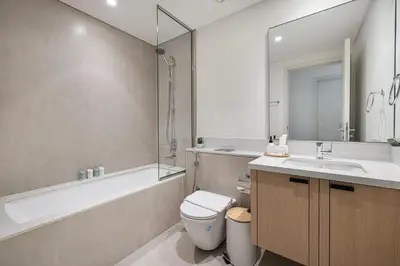 a bathroom with a toilet and a tub and a sink at Upscale 4BR Villa, Bali Pool, Resort Escape in Dubai
