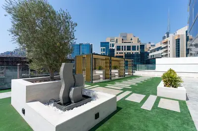 a rooftop garden with two trees and grass at 1BR in Trillionaire Residences by Binghatti with canal view in Dubai
