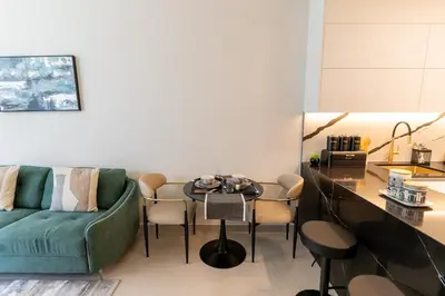 a living room with a green couch and a table at 1BR in Trillionaire Residences by Binghatti with canal view in Dubai