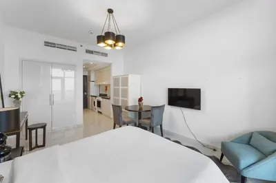 a living room with a bed and a dining room at High-Floor Studio Ghalia JVC with an Amazing View in Dubai