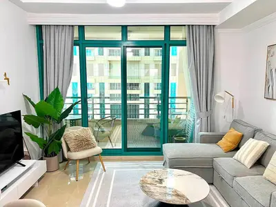 a living room with a couch and a table at Cozy 1BR Stay in Dubai Marina Near Beach and Tram in Dubai