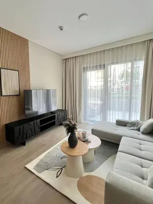 a living room with a couch and a table at Luxury 1BR with Huge Terrace with Creek Beach Lagoon in Dubai