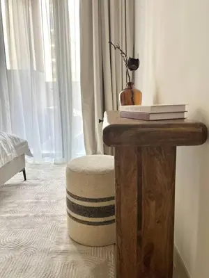 a table with books on it next to a window at Luxury 1BR with Huge Terrace with Creek Beach Lagoon in Dubai