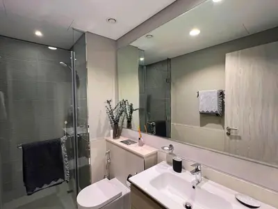 a bathroom with a sink and a toilet and a mirror at Stylish 1BR in Zada Tower near Business Bay Metro in Dubai