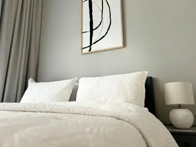 a bedroom with a bed with white sheets and a lamp at Stylish 1BR in Zada Tower near Business Bay Metro in Dubai