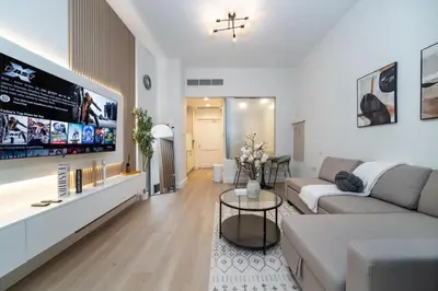 a living room with a couch and a tv at Luxury Upgraded Palm Studio with Marina and Yacht Views in Dubai