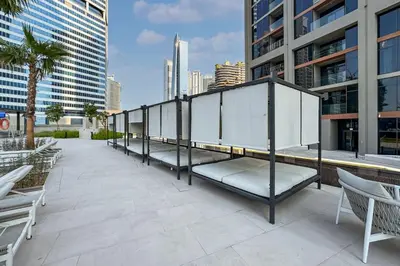 a row of benches on a patio in a city at Modern Studio in Peninsula One with Canal Views in Dubai