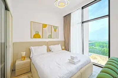 a bedroom with a white bed and a large window at Chic Living in Meraki comfy studio in Dubai
