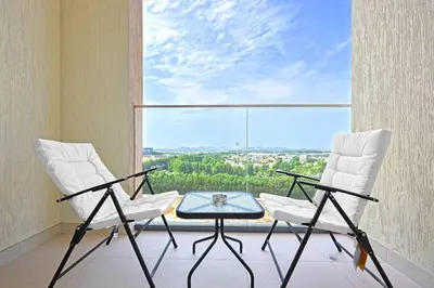two chairs and a table in front of a large window at Chic Living in Meraki comfy studio in Dubai