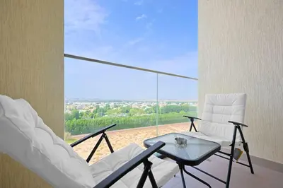 a balcony with a table and chairs and a view at Chic Living in Meraki comfy studio in Dubai