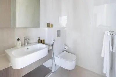 a white bathroom with a sink and a toilet at Frank Porter - Peninsula Five, Business Bay in Dubai