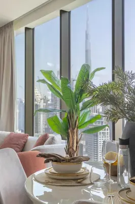 a table with a plant on it in front of a window at Frank Porter - Peninsula Five, Business Bay in Dubai