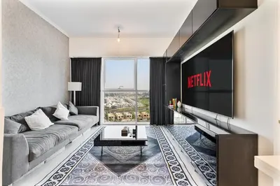 a living room with a couch and a flat screen tv at Modern 1Bed near Parks and Famous Golf Clubs in Dubai