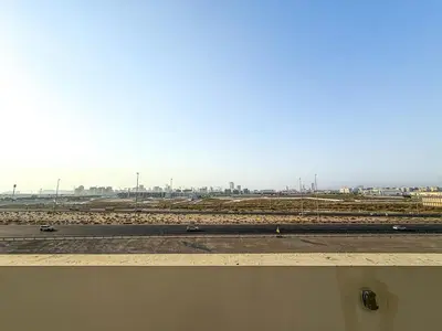 a view of a highway with a city in the background at Modern 1Bed near Parks and Famous Golf Clubs in Dubai
