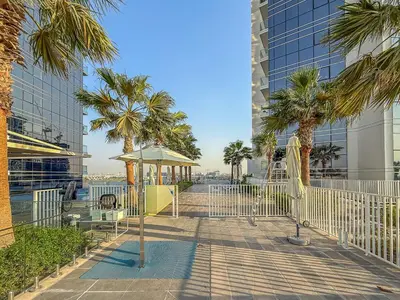 a playground with a gazebo and palm trees in a city at Modern 1Bed near Parks and Famous Golf Clubs in Dubai