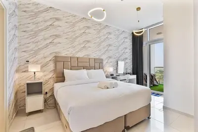 a bedroom with a large bed and a stone wall at Modern 1Bed near Parks and Famous Golf Clubs in Dubai