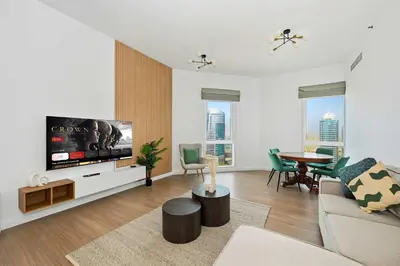 a living room with a large flat screen tv at Spacious modern 2 Bed and Maids I Sleeps 7 in Dubai