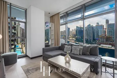 a living room with a couch and a large window at LUX The 15 Northside Burj Khalifa View Suite in Dubai