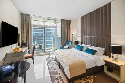 a bedroom with a bed and a desk and a television at Bays edge in Dubai