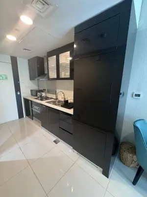 a large kitchen with black cabinets and a sink at Bays edge in Dubai