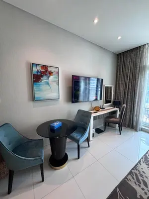 a room with a table and chairs and a desk at Bays edge in Dubai