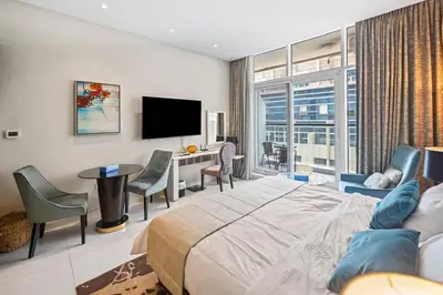 a bedroom with a bed and a desk and a tv at Bays edge in Dubai