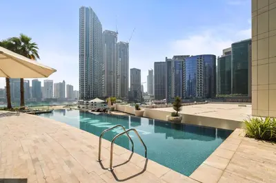 a swimming pool in a city with tall buildings at Bays edge in Dubai