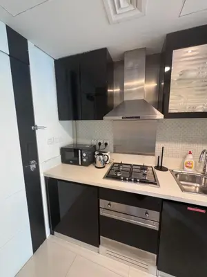 a kitchen with black cabinets and a stove top oven at Bays edge in Dubai