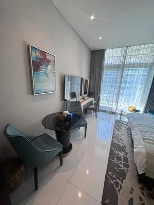 a hotel room with a bed and a table and chairs at Bays edge in Dubai