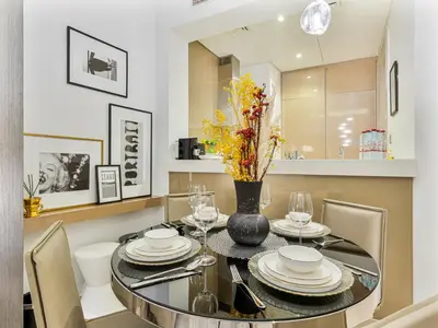 a dining room with a glass table and chairs at Savis Homes - Stylish 1BR in Business Bay with Burj Khalifa View in Damac Paramount Tower in Dubai