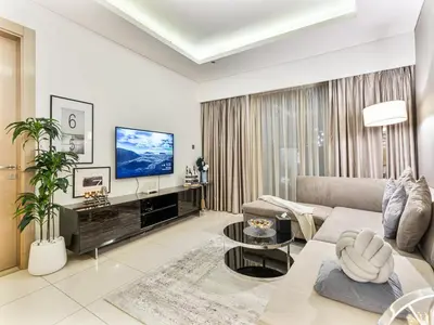 a living room with a couch and a tv at Savis Homes - Stylish 1BR in Business Bay with Burj Khalifa View in Damac Paramount Tower in Dubai
