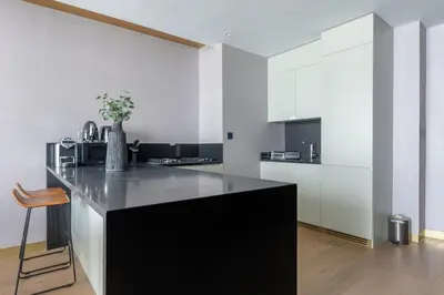 a kitchen with a black island in a room at The Opus residences 1 bedroom city view in Dubai