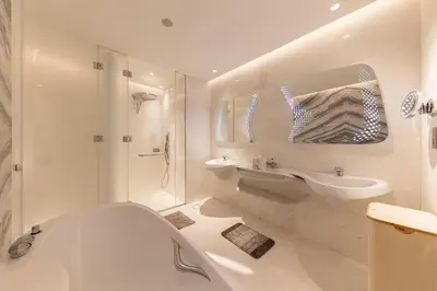 a white bathroom with a tub and a sink at The Opus residences 1 bedroom city view in Dubai