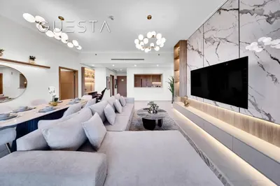 a living room with couches and a tv on a wall at Vida Residences The Hills, Dubai in Dubai