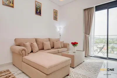 a living room with a couch and a large window at Splendour Living 1BR at Azizi Riviera in Dubai
