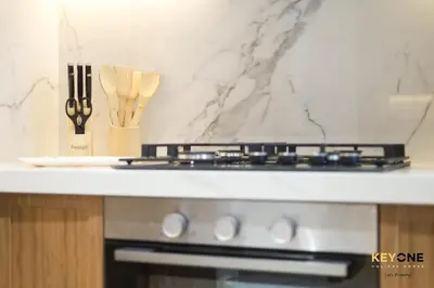 a kitchen counter with a stove and some utensils at Splendour Living 1BR at Azizi Riviera in Dubai