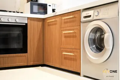 a kitchen with a dishwasher and a washing machine at Splendour Living 1BR at Azizi Riviera in Dubai