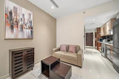 a living room with a couch and a table at FIRST CLASS Studio Cozy with City Vibes in Dubai