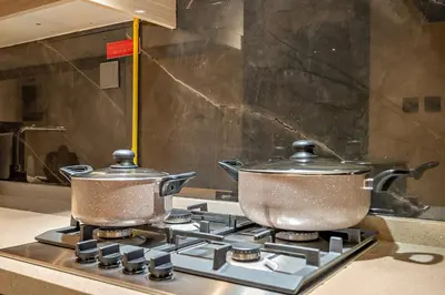 two pots on top of a stove in a kitchen at FIRST CLASS Studio Cozy with City Vibes in Dubai